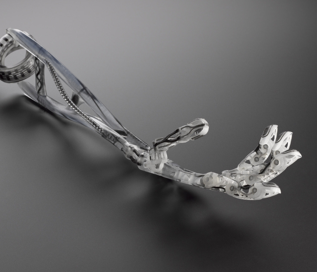 3D Printed bionic arm design for 21st century 2010s 3D Printed bionic arm laying on grey surface.